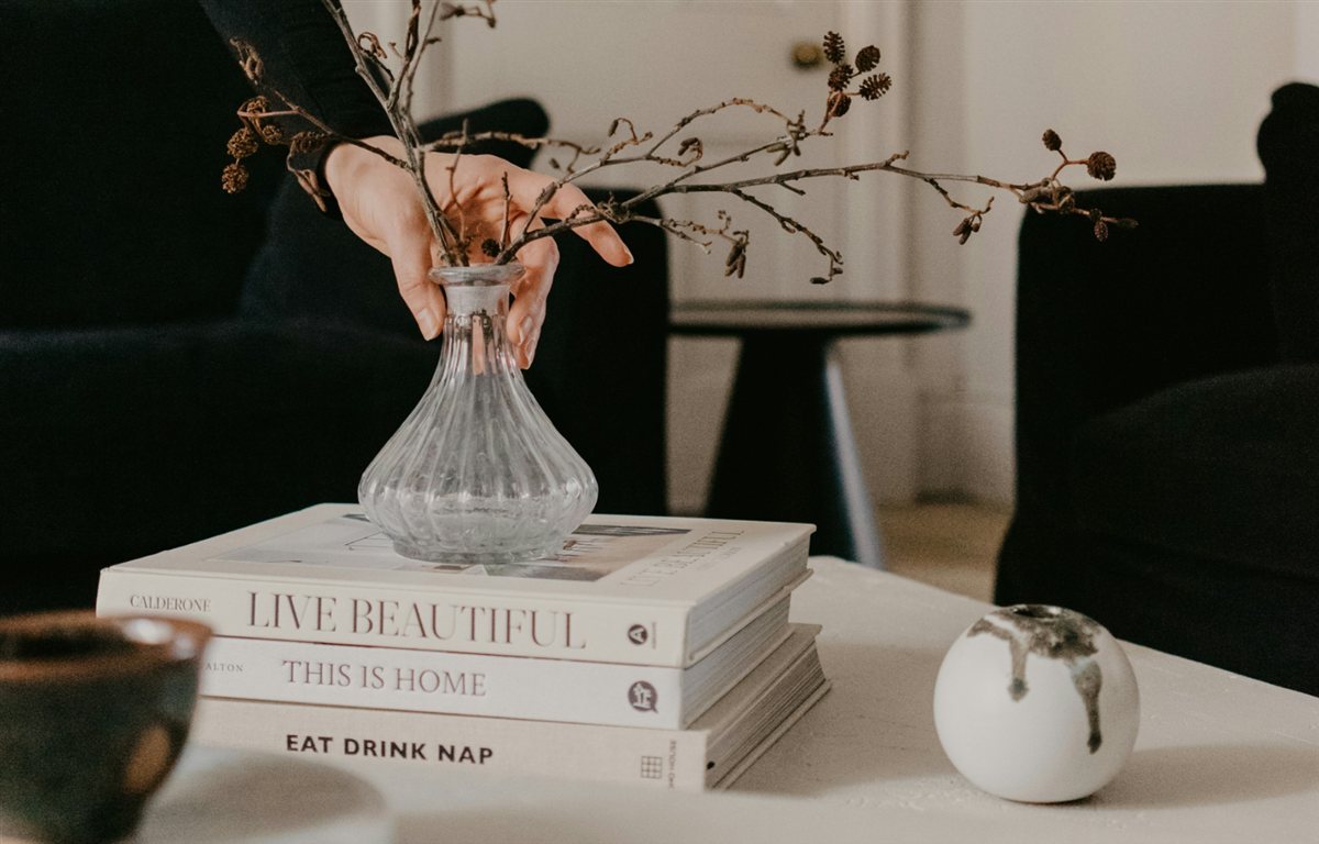 Stylist arranging branches in a vase during home staging
